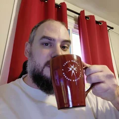 Jon, sipping coffee from a red mug
